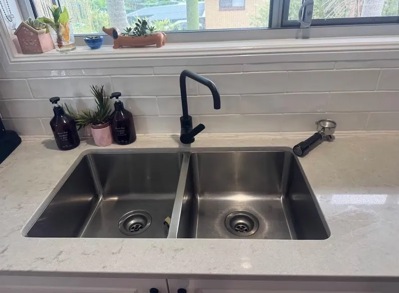 Spotless stainless steel kitchen sink and polished faucet detailed for rental exit handover